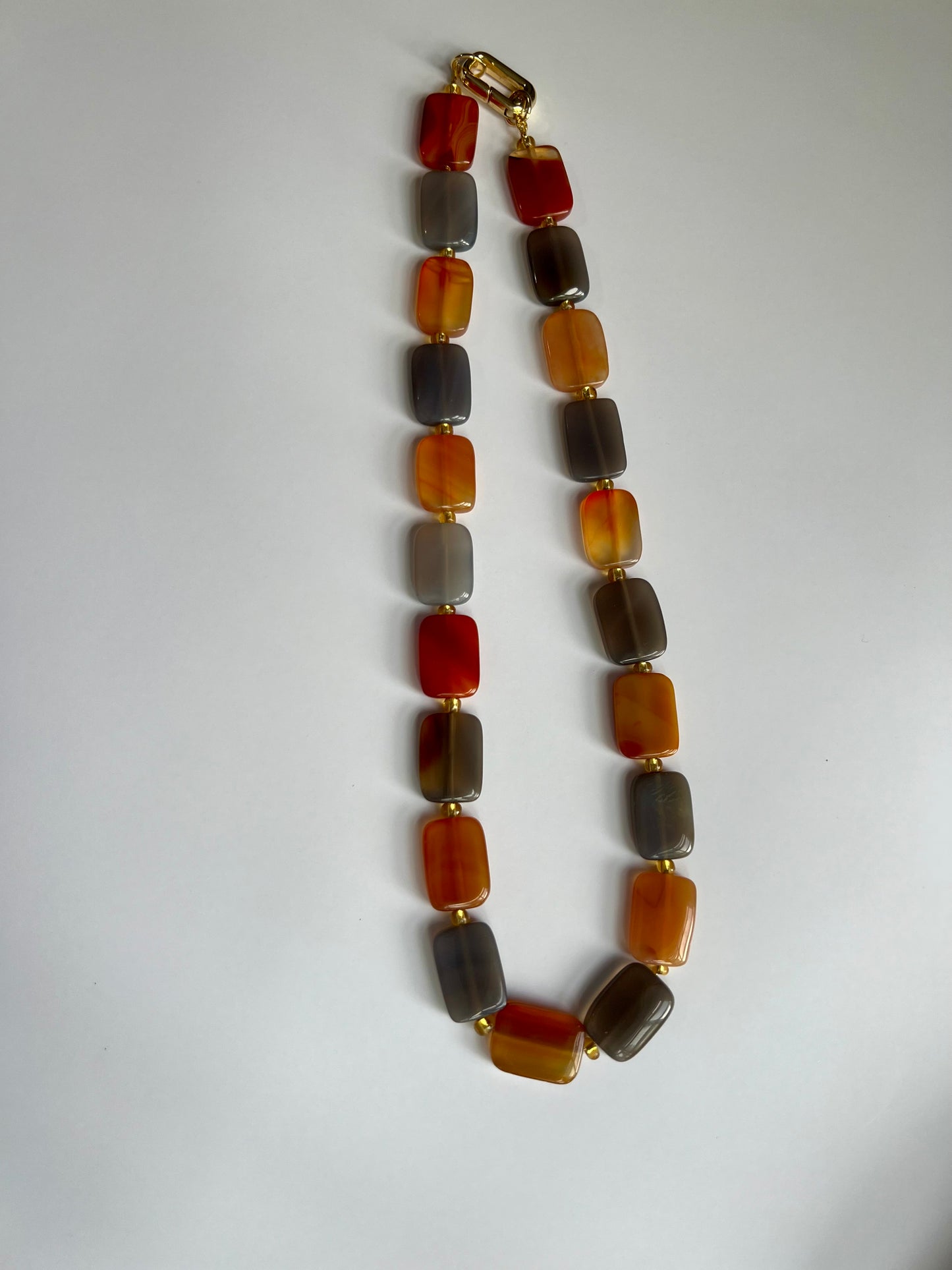 a multicolored beaded necklace on a white surface