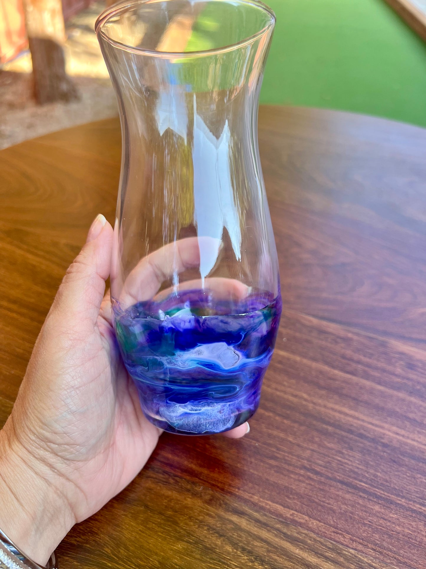 a person holding a glass with blue liquid in it