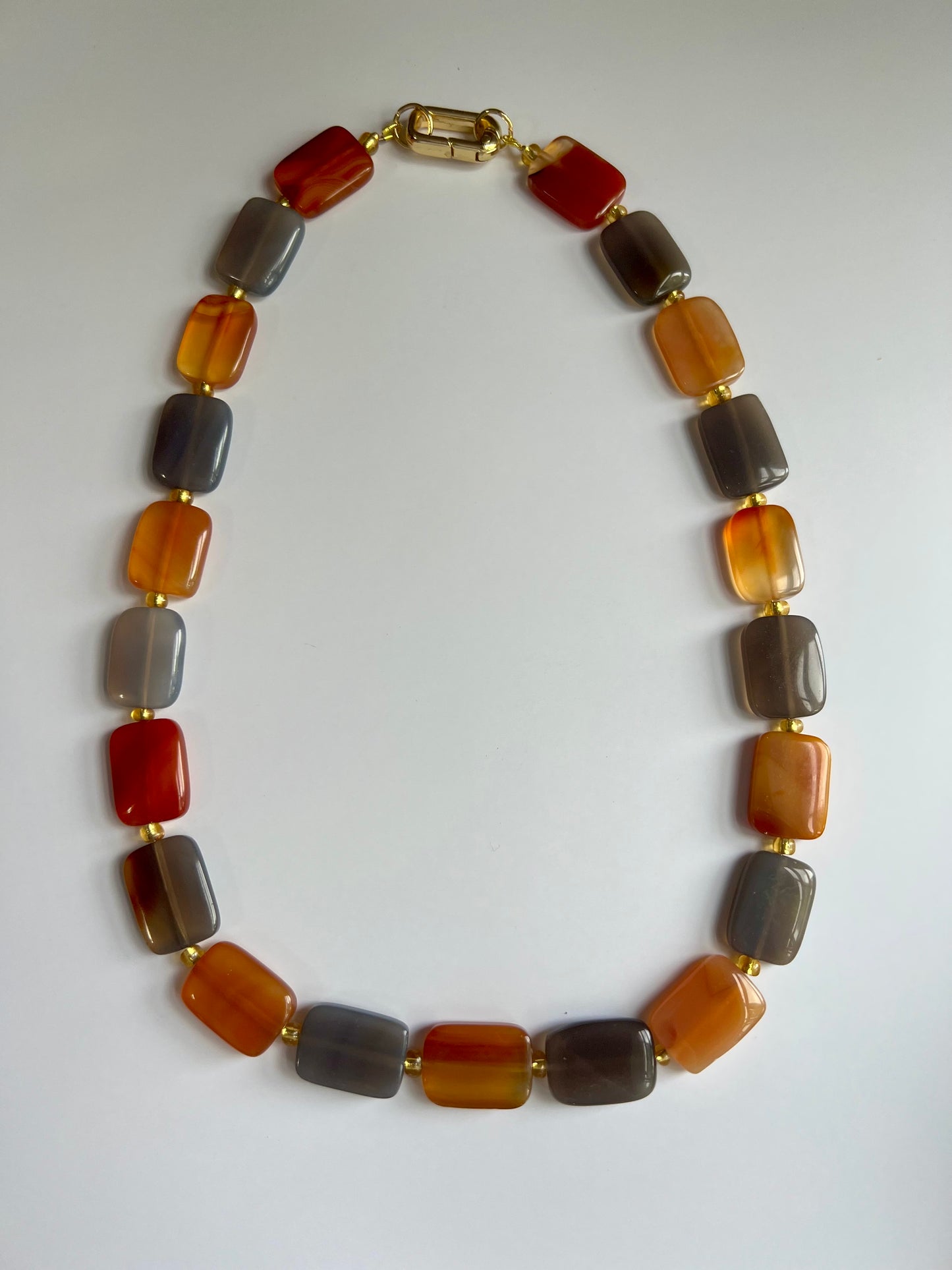 a multicolored beaded necklace on a white surface