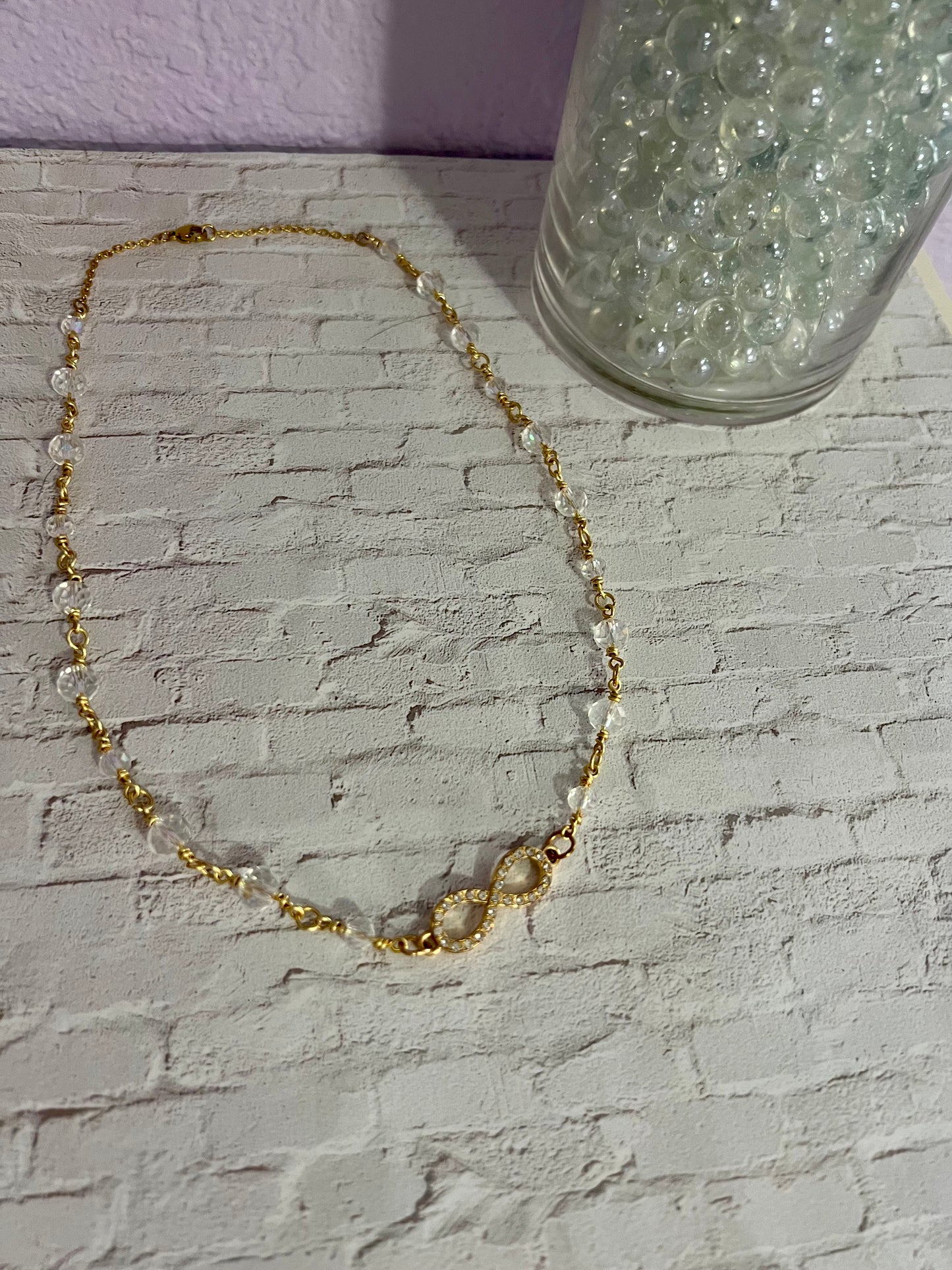 a gold chain bracelet with a glass of water