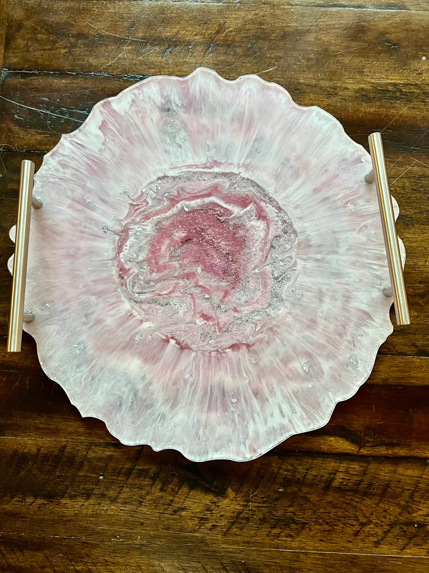 a pink and white plate sitting on top of a wooden table