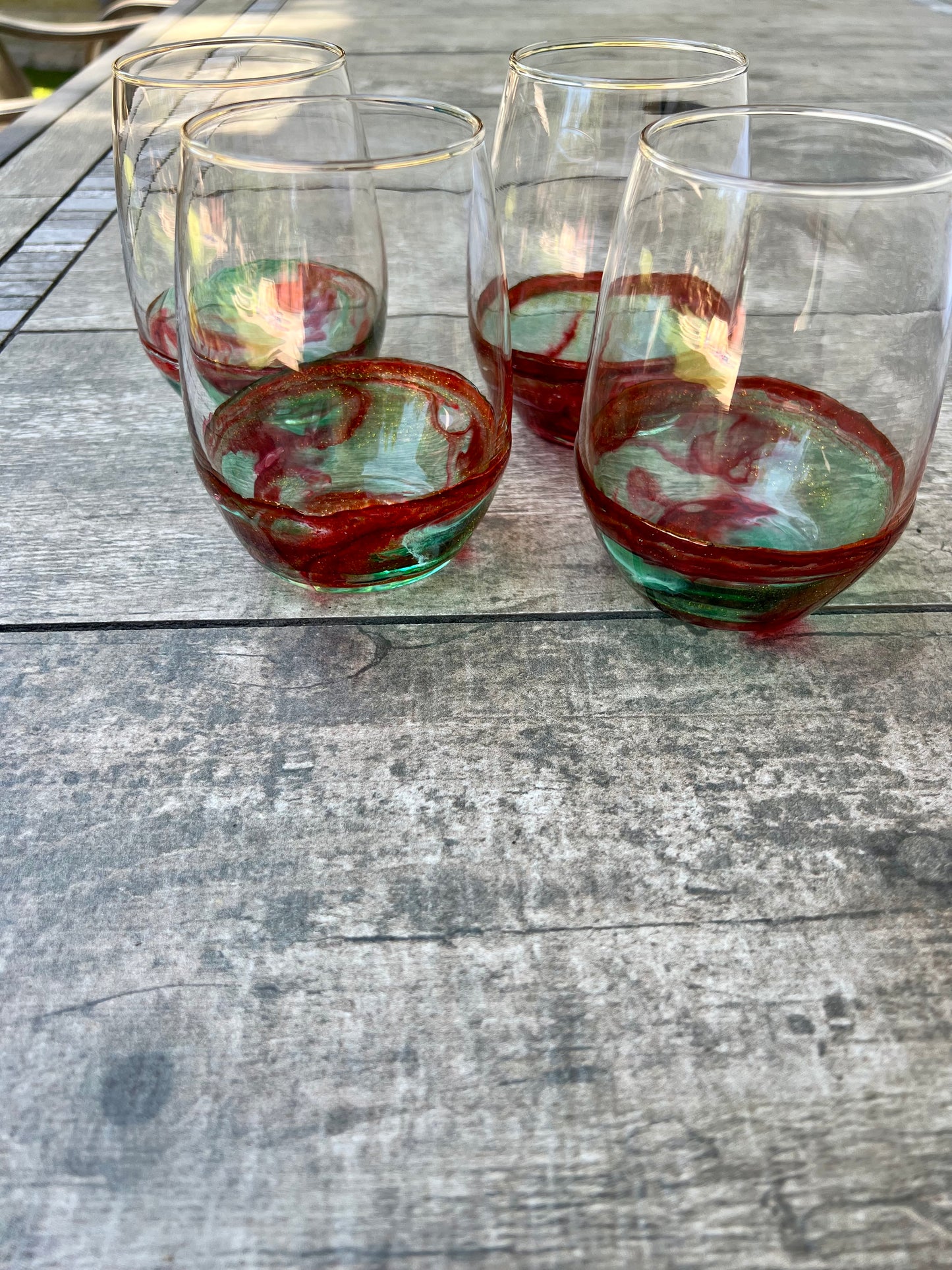 a collection of wine glasses on a wooden table, with a few of them containing a red liquid.