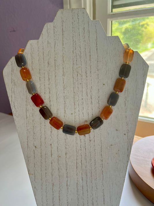 a necklace is displayed on a wooden stand