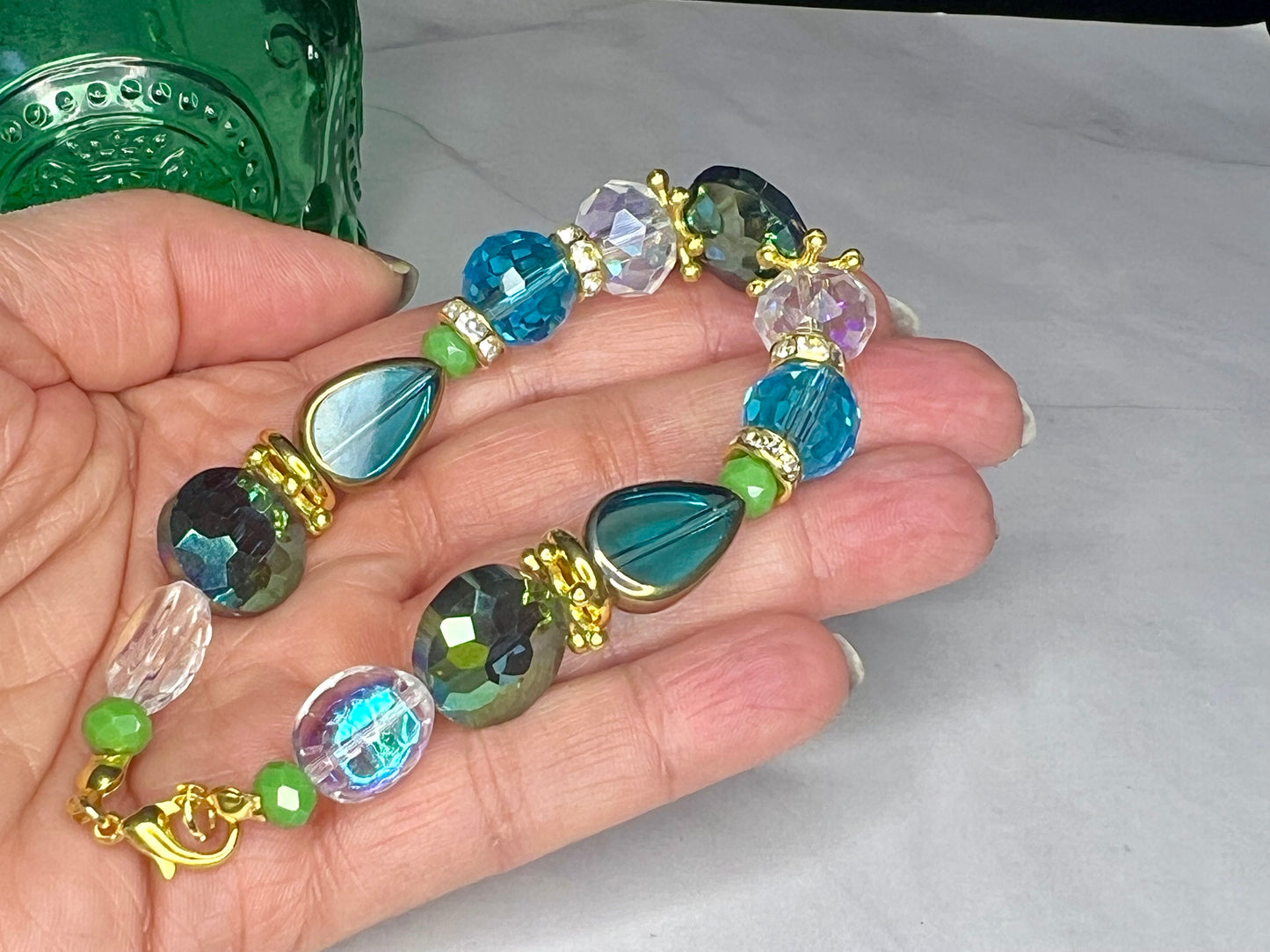 a person is holding a bracelet made of glass beads