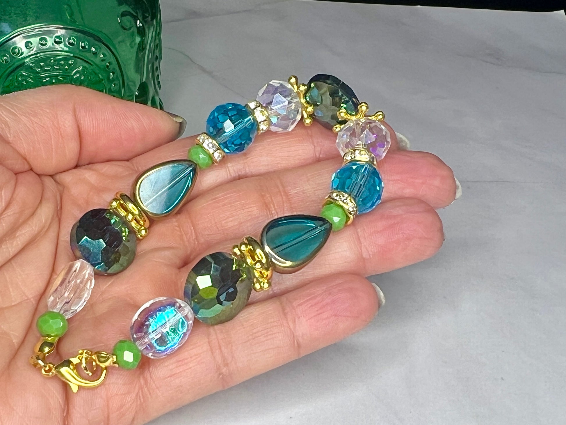 a person is holding a bracelet made of glass beads