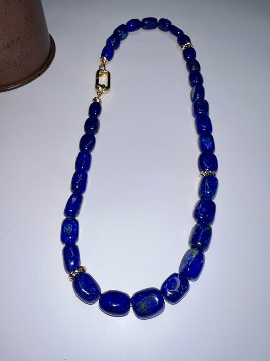 a blue beaded necklace on a white table