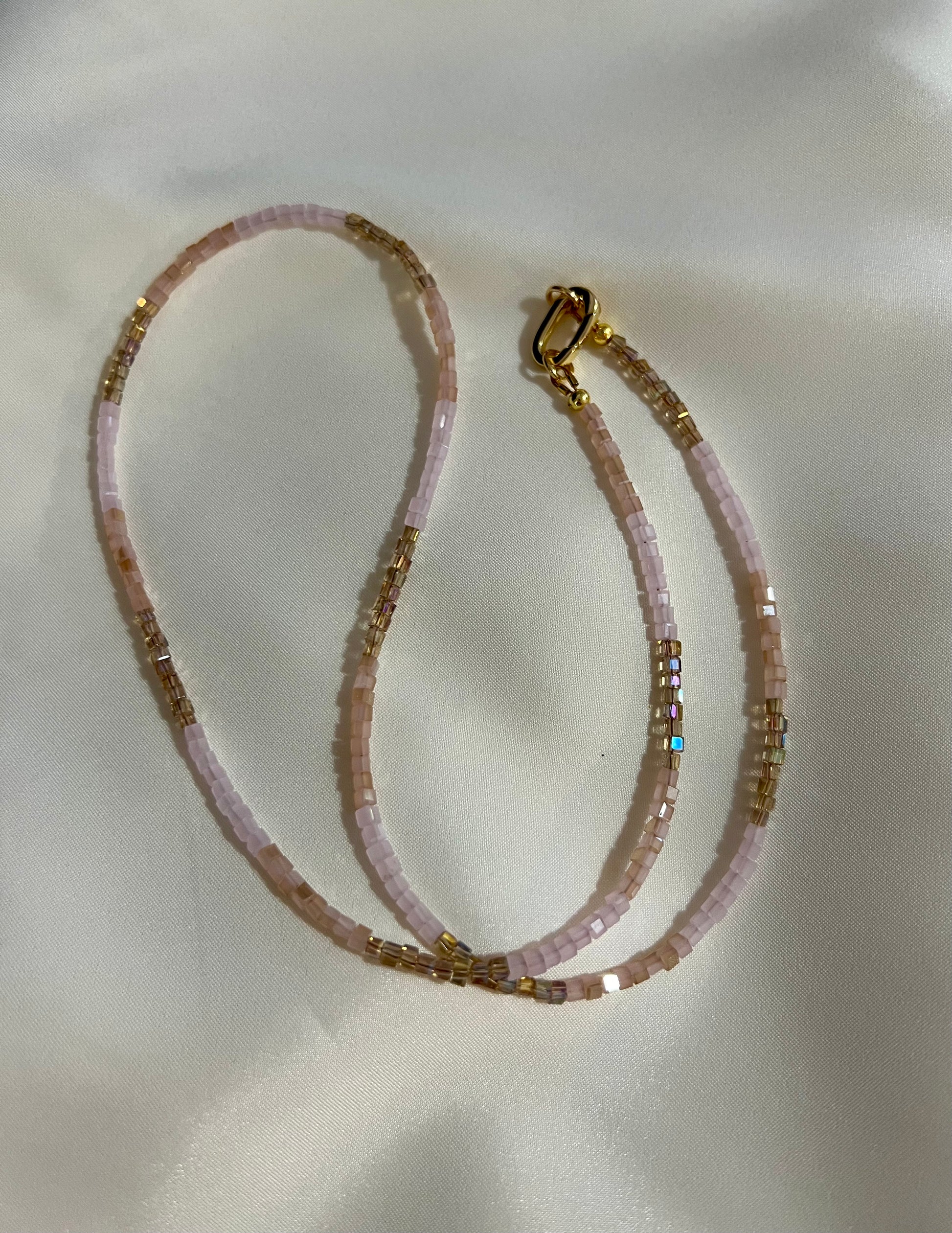 a close up of a necklace on a white cloth