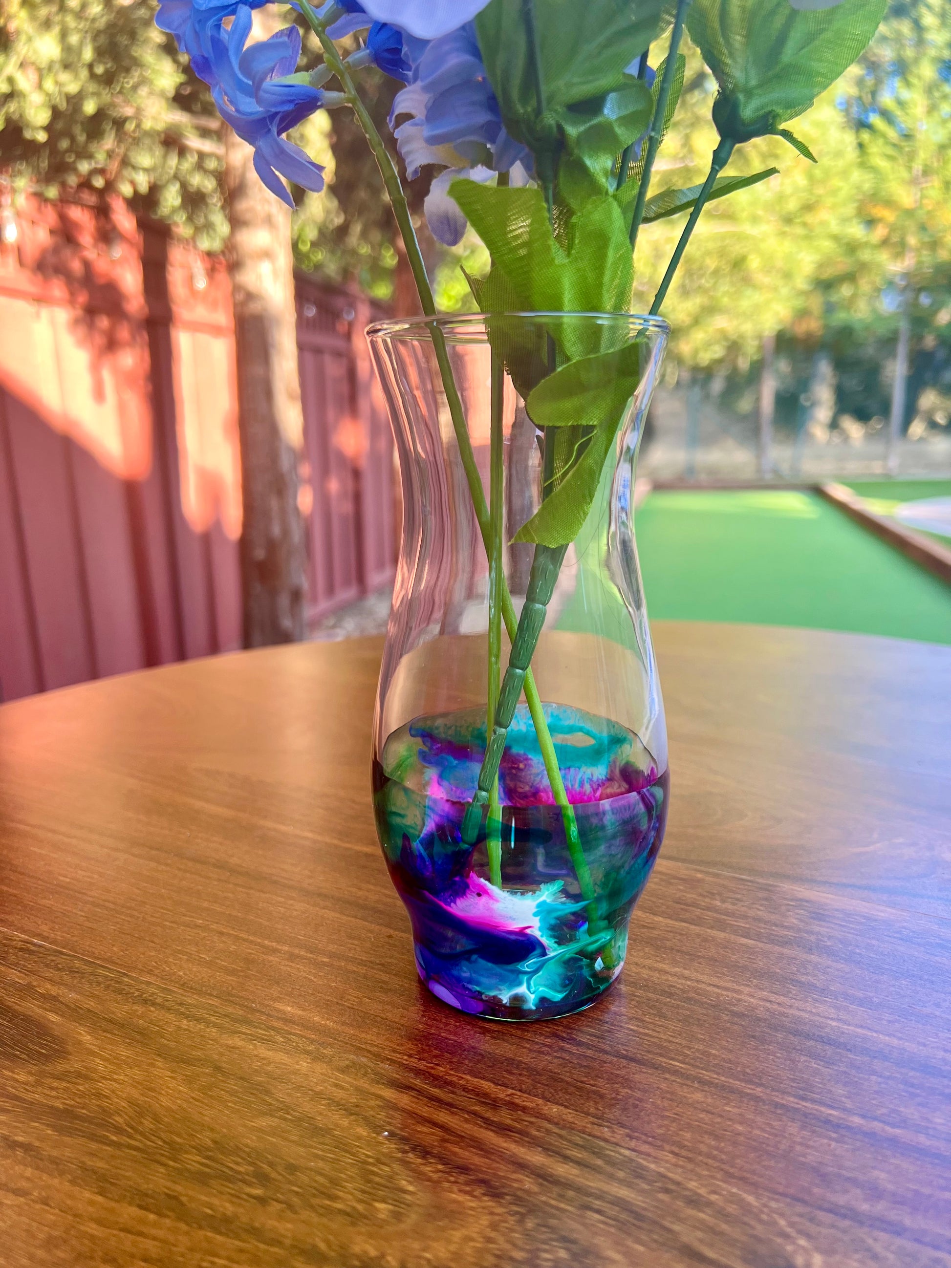 a vase filled with blue flowers on top of a wooden table