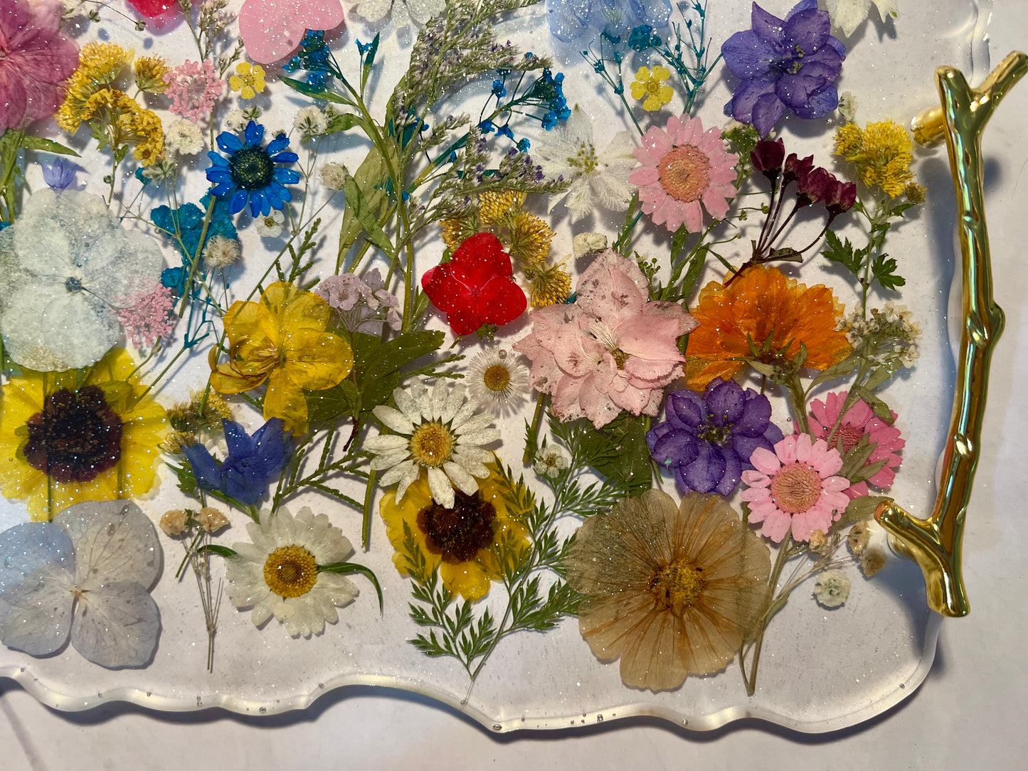 a tray filled with a variety of colorful flowers, including sunflowers, daisies, and other blooms.