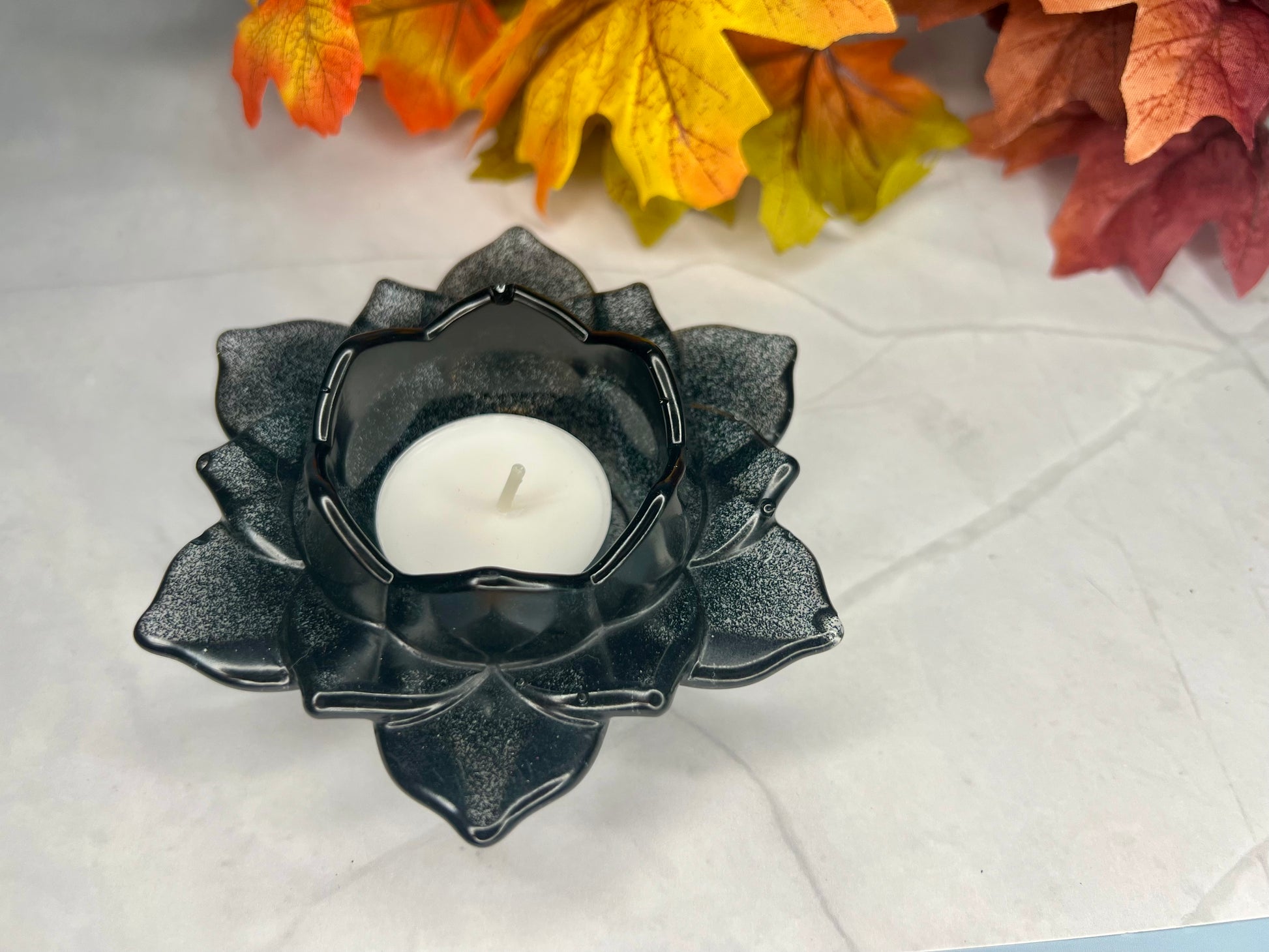 a black candle holder sitting on top of a table