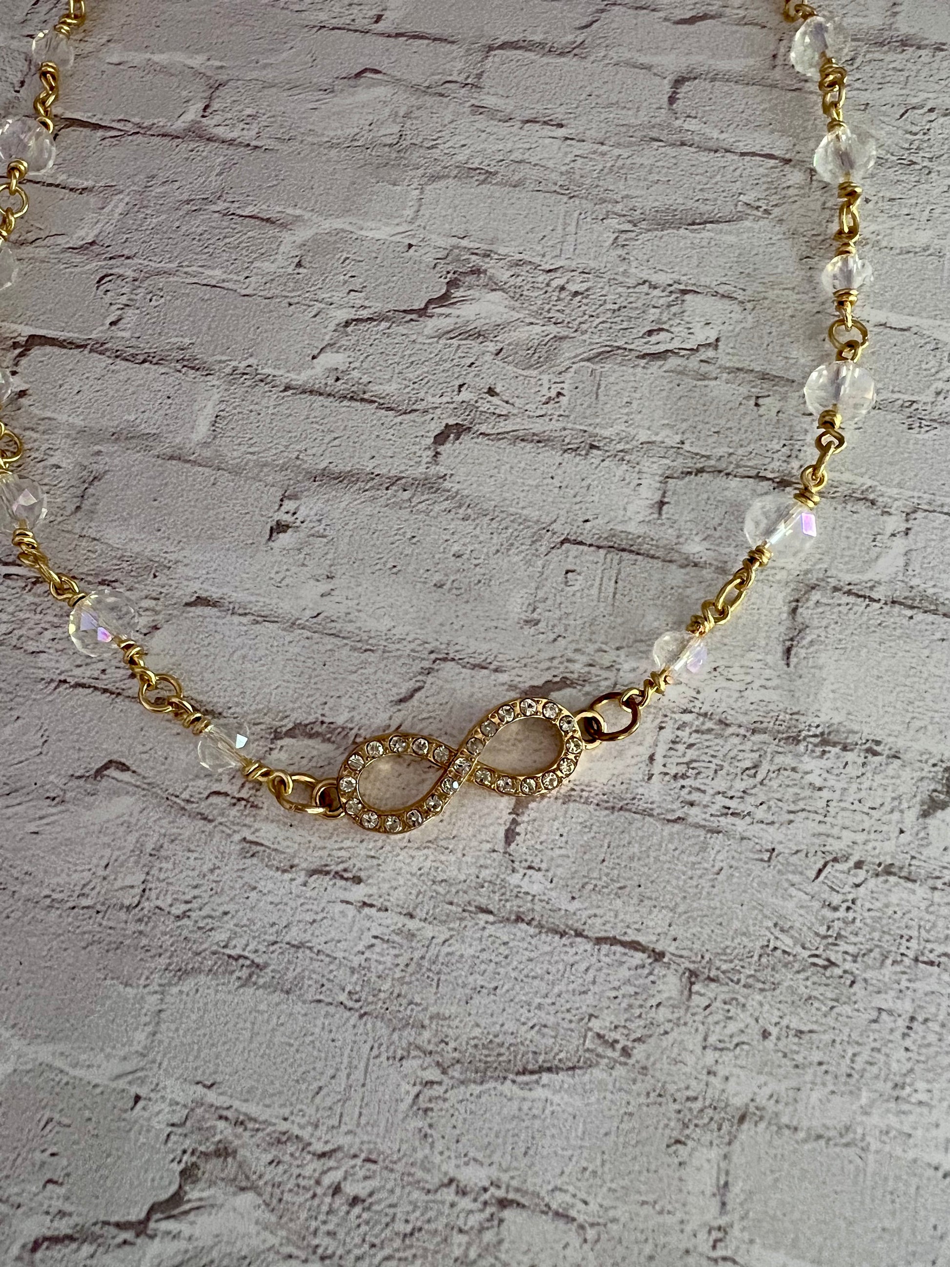 a gold chain with a white beaded bracelet