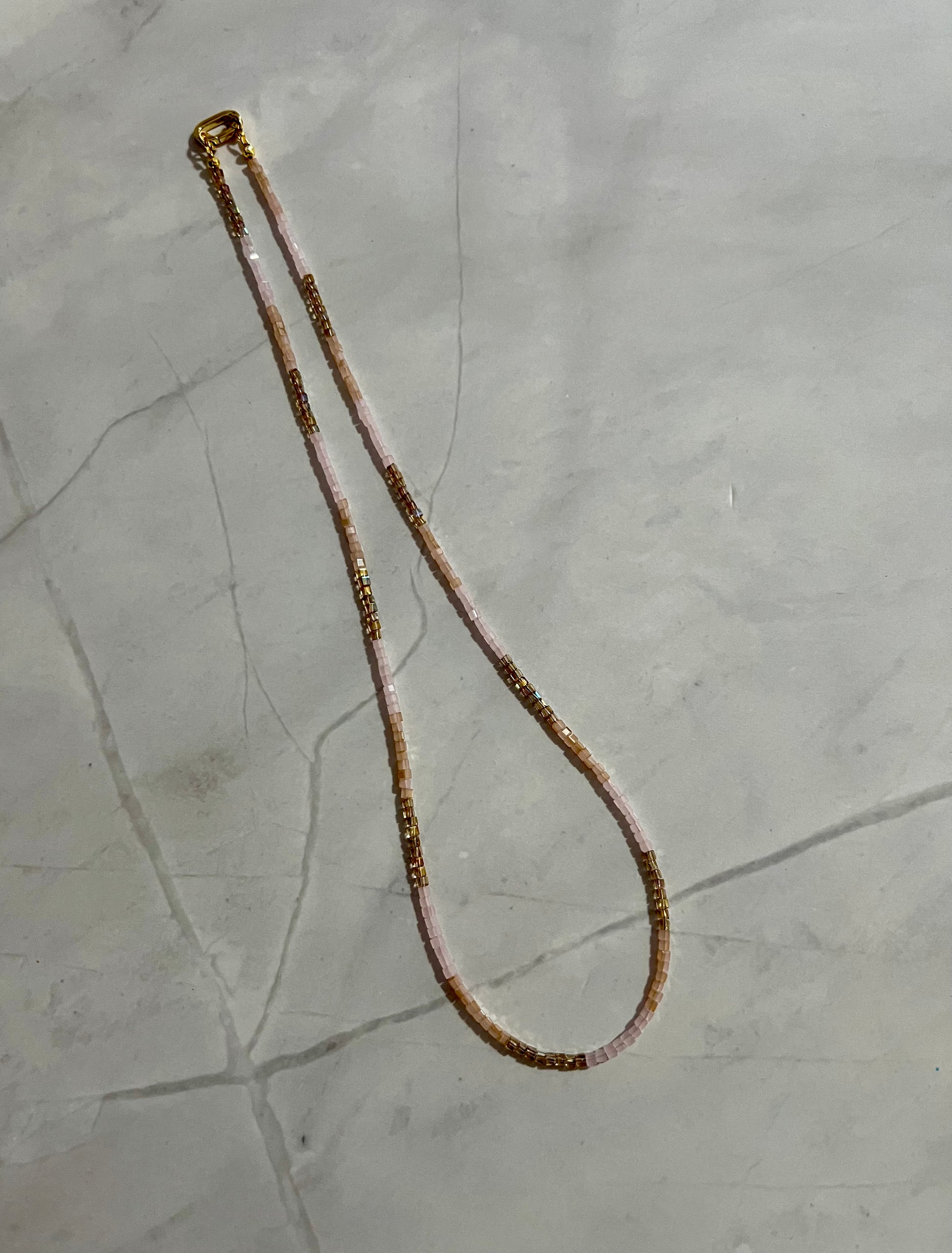 a long beaded necklace on a marble surface