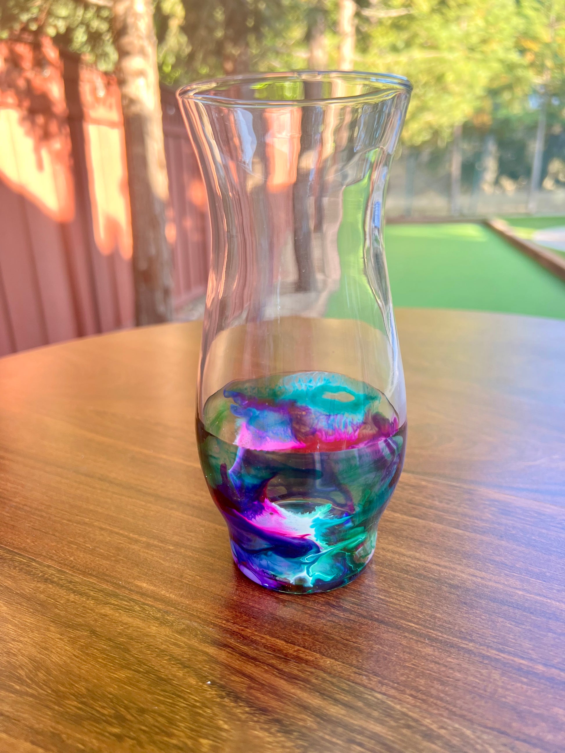 a glass filled with liquid sitting on top of a wooden table