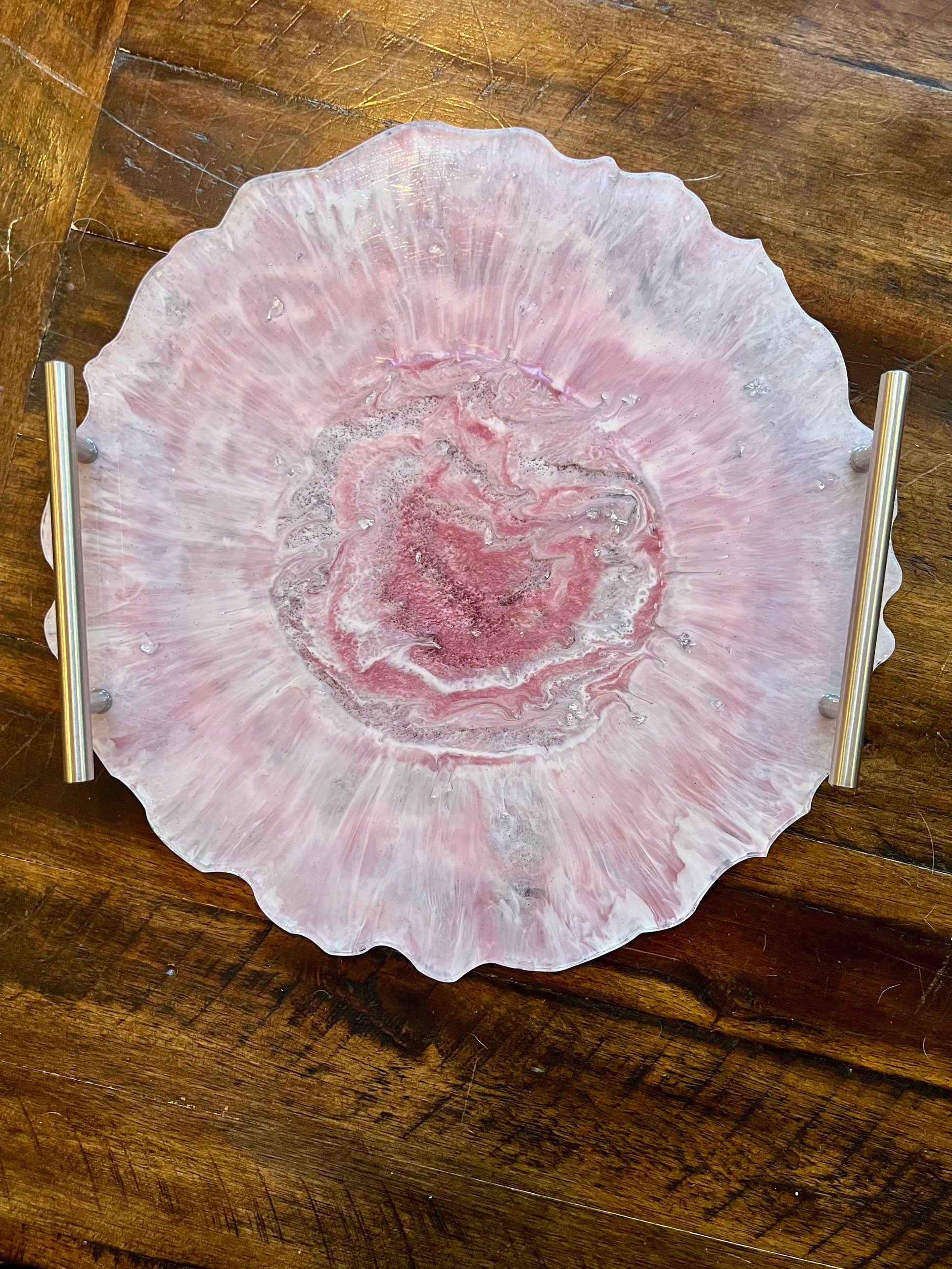 a pink plate sitting on top of a wooden table